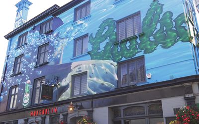 A four story pub painted with a blue mural and a sign saying The Hobgoblin Brighton