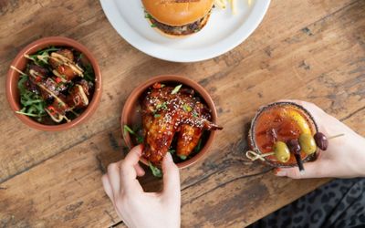 over head shot of the person taking friend chicken from brown bowl