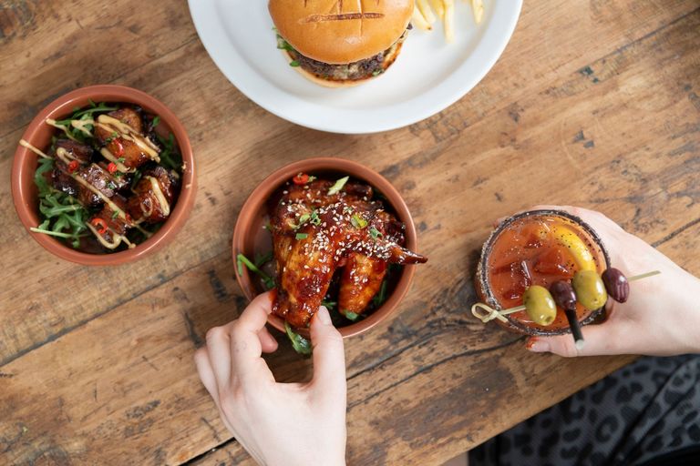 over head shot of the person taking friend chicken from brown bowl