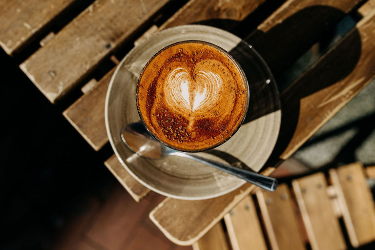 over head shot of the flat white coffee served on wooden table at Trading Post Coffee