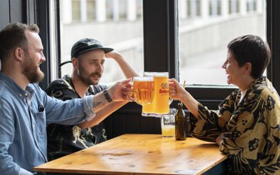 Friends toasting with pints. Six nations Championship. Where to watch rugby in Brighton