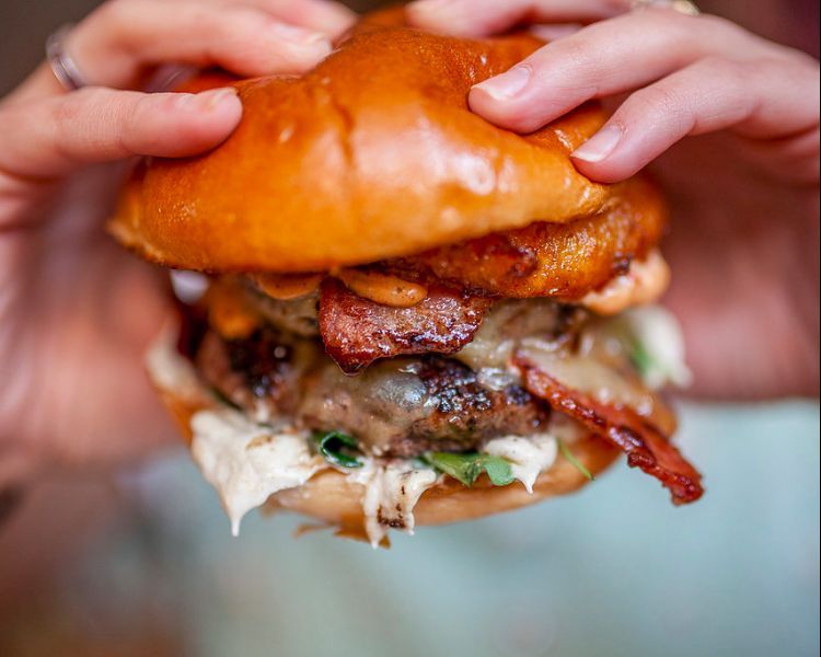 Holding a burger at Sidekick Kitchen