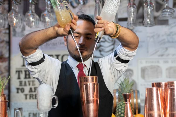 Bartender sipping alcohol in cocktail shaker