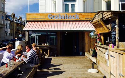 Exterior photo of The CrabShack, Sussex on a sunny day with people sitting outside eating.
