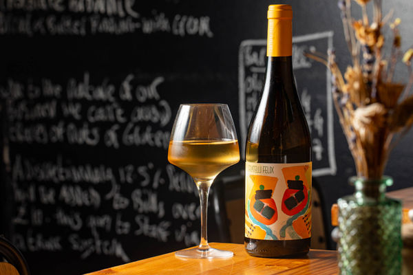 shot of the bottle and glass of the wine served on the table at Mange Tout