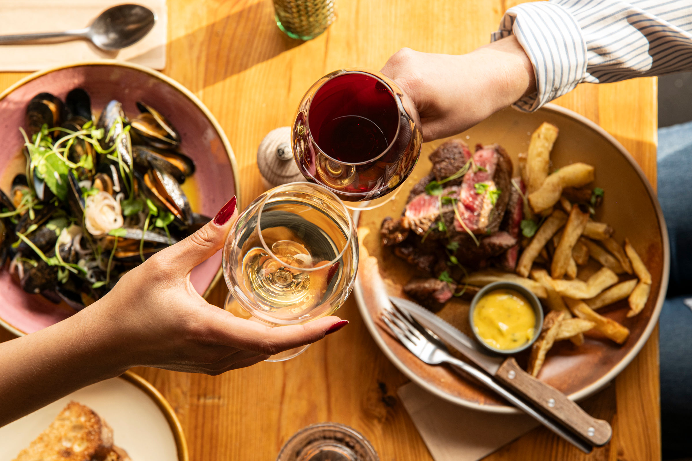two people having a toast with glasses of wine at Mange Tout 