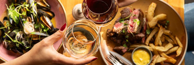 two people having a toast with glasses of wine at Mange Tout
