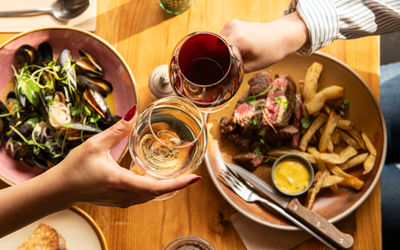 two people having a toast with glasses of wine at Mange Tout