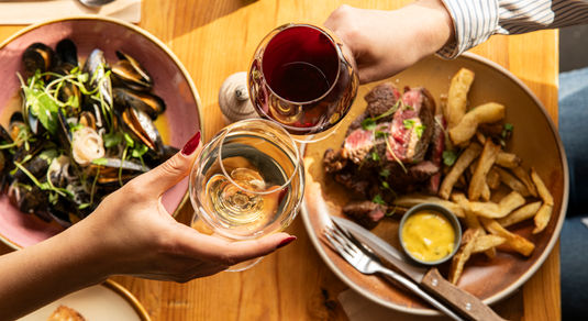 two people having a toast with glasses of wine at Mange Tout