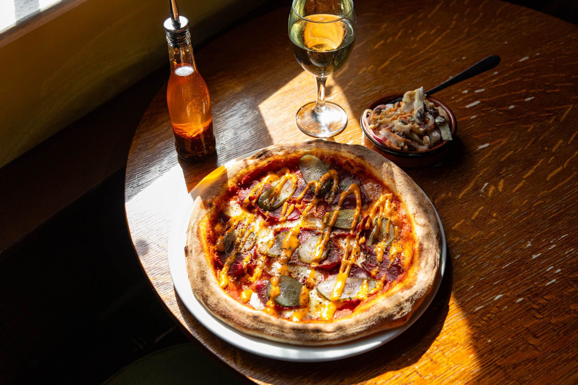 meat pizza served with glass of wine