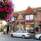 Street view exterior shot of The Plough Inn with pink flower baskets