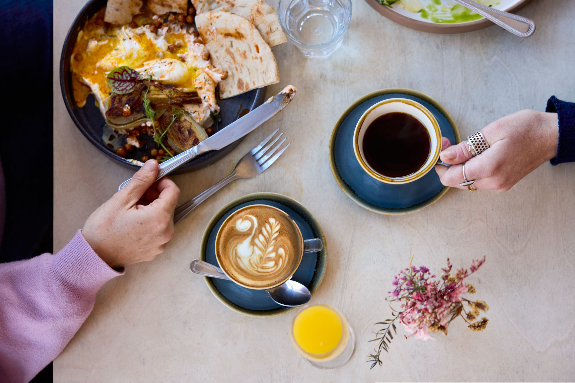 over head shot of the americano, flat white and plate with brunch dish