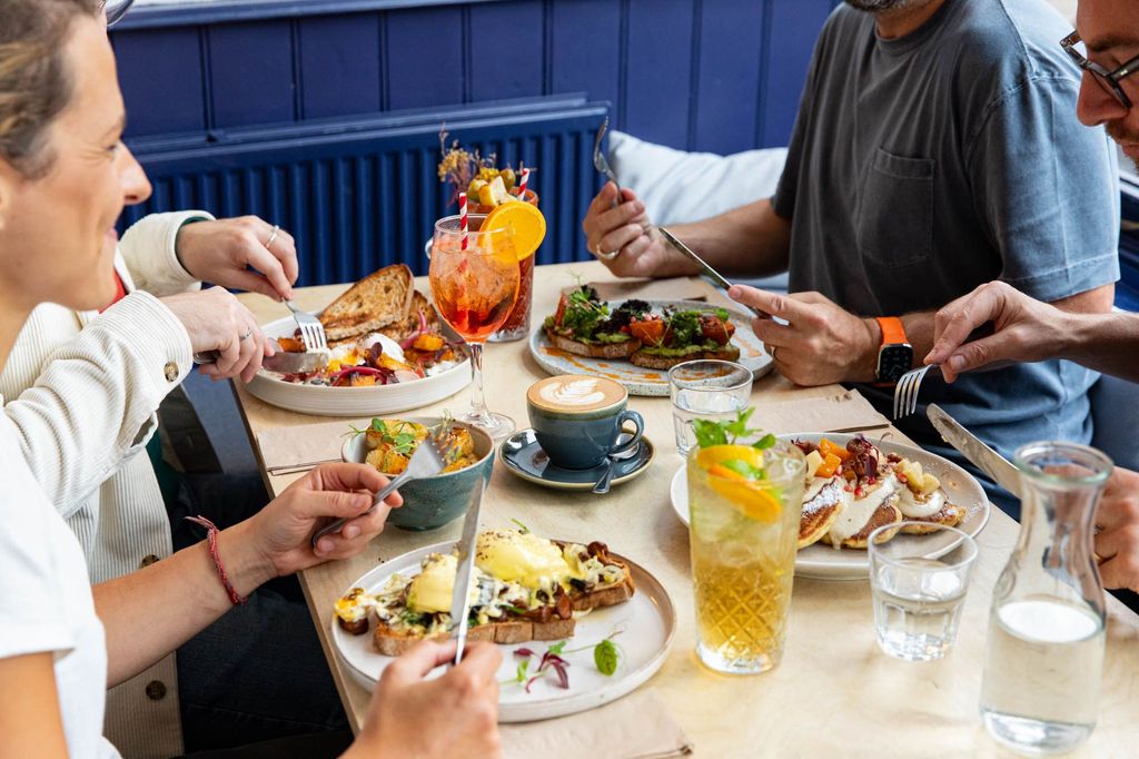 Starfish and Coffee located near Queens Park in Brighton. Finishing Third in 2025 - Best Brunch Brighton. A table of diners enjoying a variety of brunch dishes, with plenty of colourful plates of food.