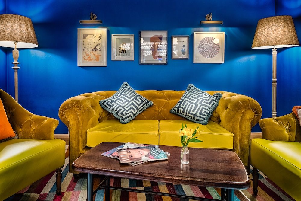 yellow sofa against a striking blue wall. Pictures on the wall, coffee table with magazine