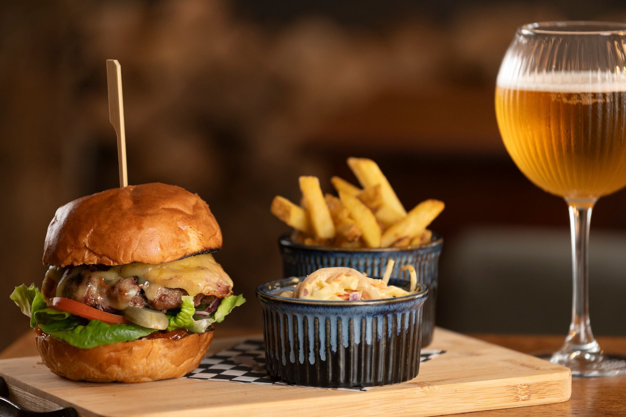 delicious looking burger served with coleslaw, chips and glass of beer at the new inn