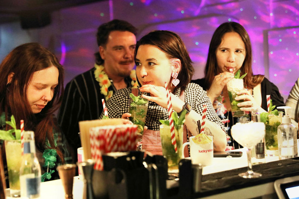 a lady sipping a drink at the Lucky Voice karaoke bar in Brighton