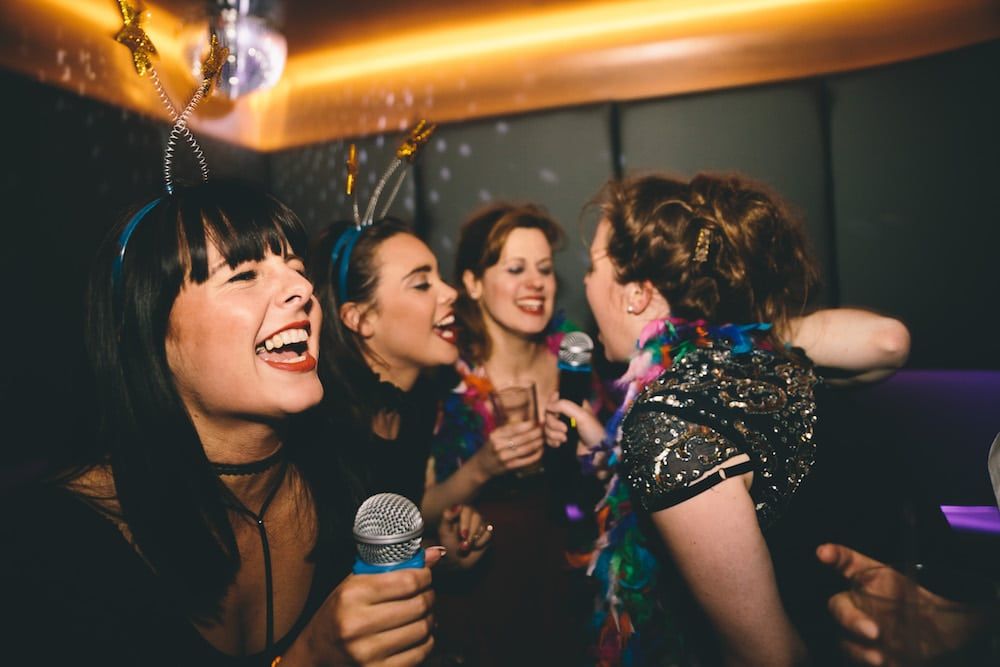 People enjoying singing together at a karaoke booth
