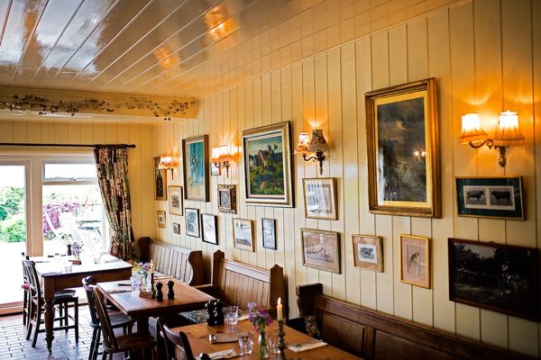 Interior shot of the Sussex Ox, tables and chairs with pictures decorating the wall.