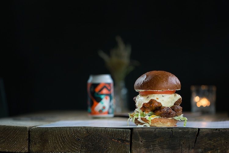 Chicken burger on a wooden table in the Joker pub