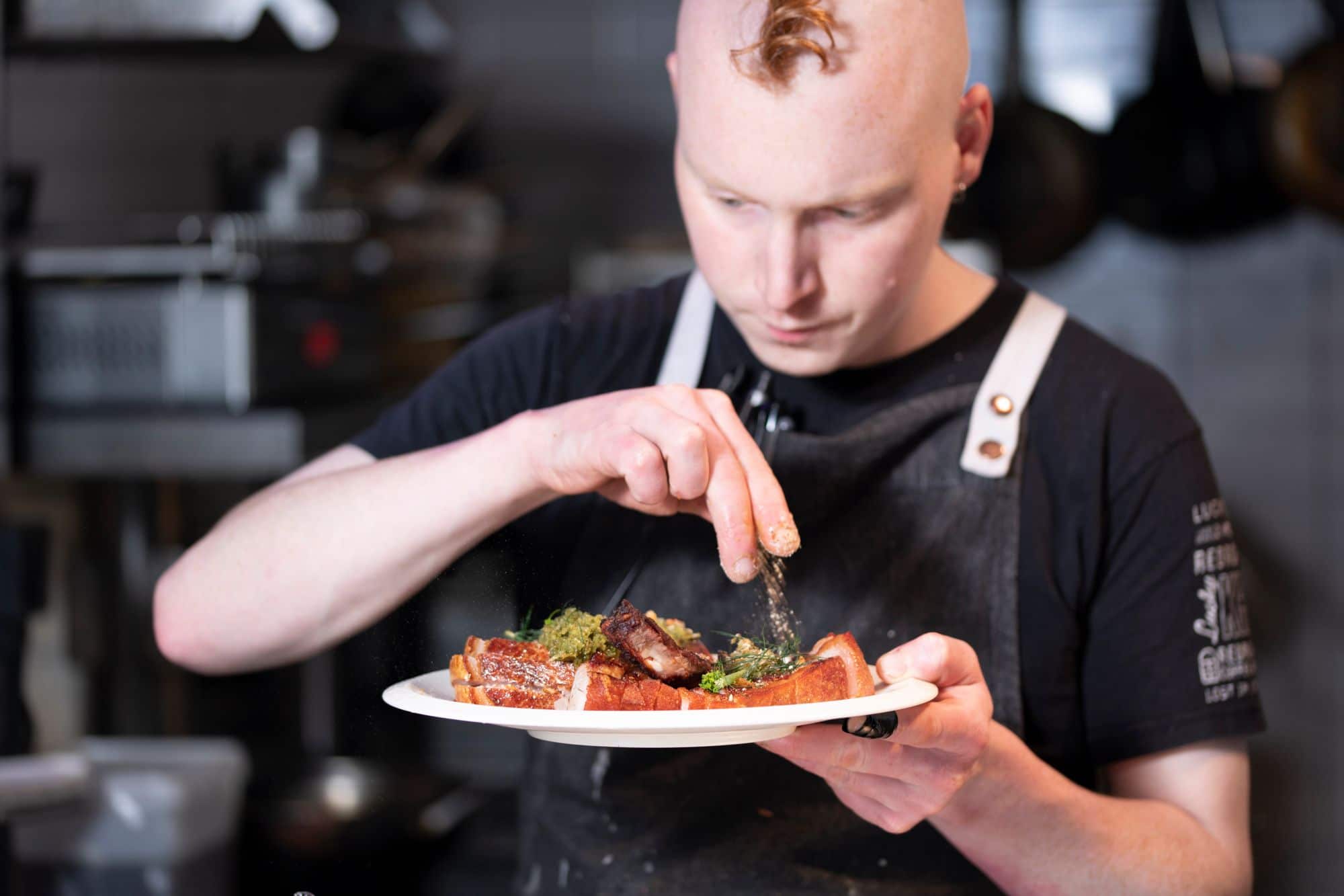 chef holding plate and decorating dish