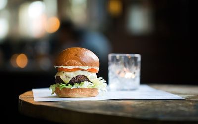 Brioche bun burger with lettuce and cheese served with a cocktail