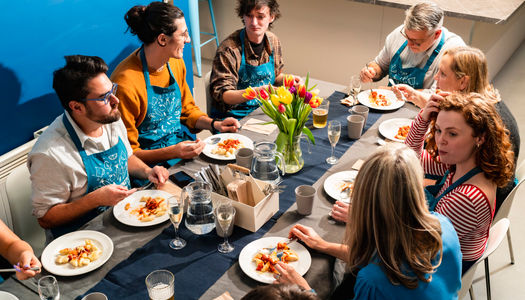 Brighton Community Kitchen - people at the cooking class sitting and eating the dish they prepared
