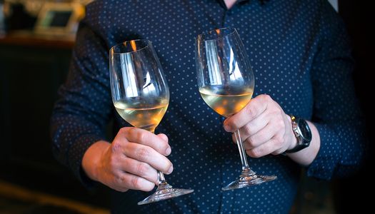 Man in elegant blue shirt holding glasses of wine. Brighton catering companies