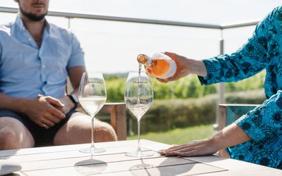 man and woman sitting ourside of Albourne Estate and enjoying their wine