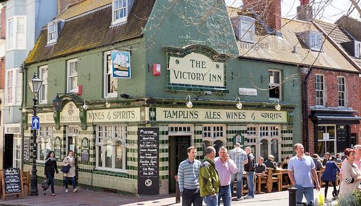 The Victory Inn pub in Brighton situated in The Lanes Brighton. a crowd of pub goers stood in the cobbled street in front of the Victory pub.