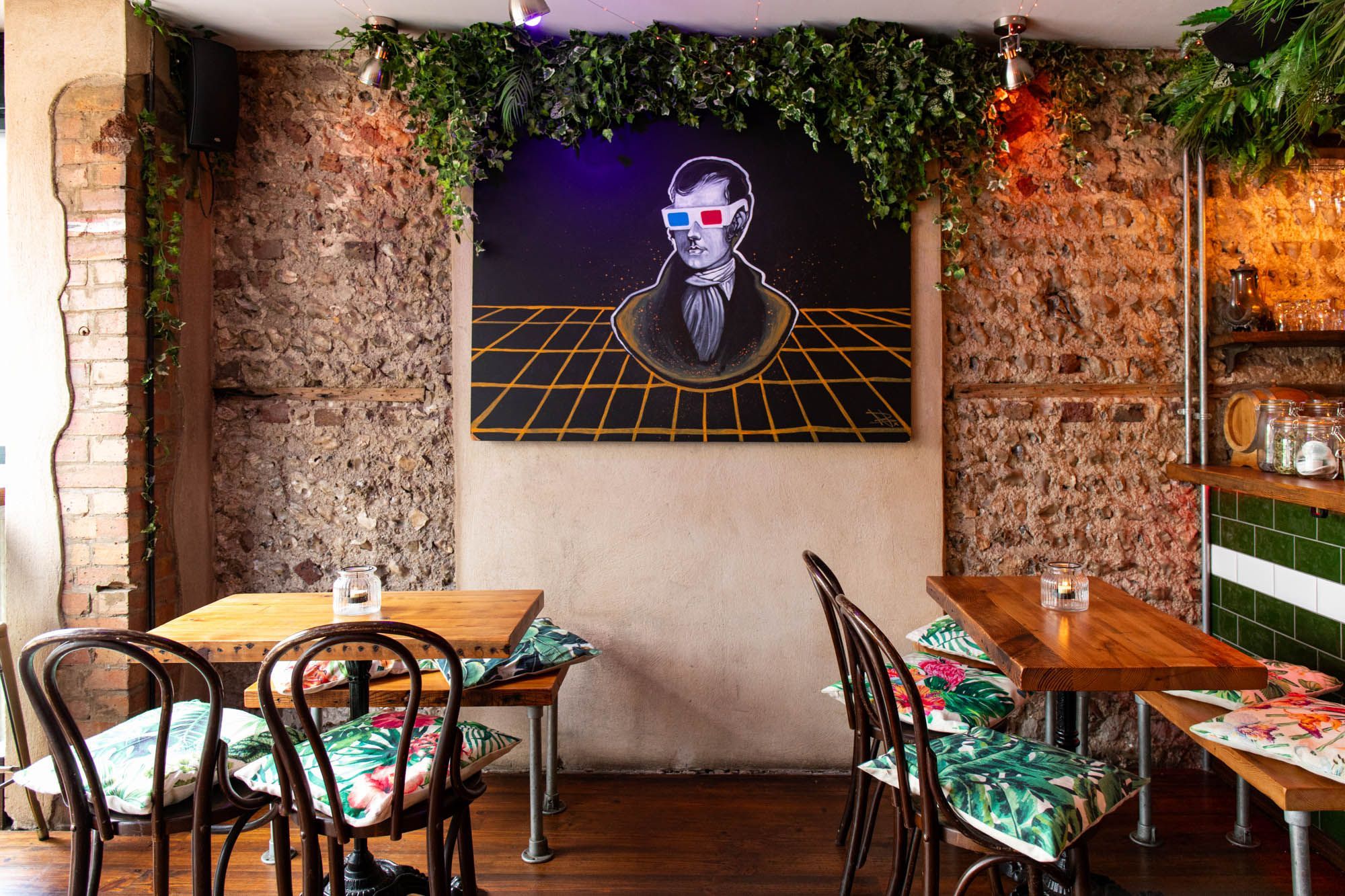 interior shot of the Gung Ho bar Brighton wooden tables and chairs with flower pillows