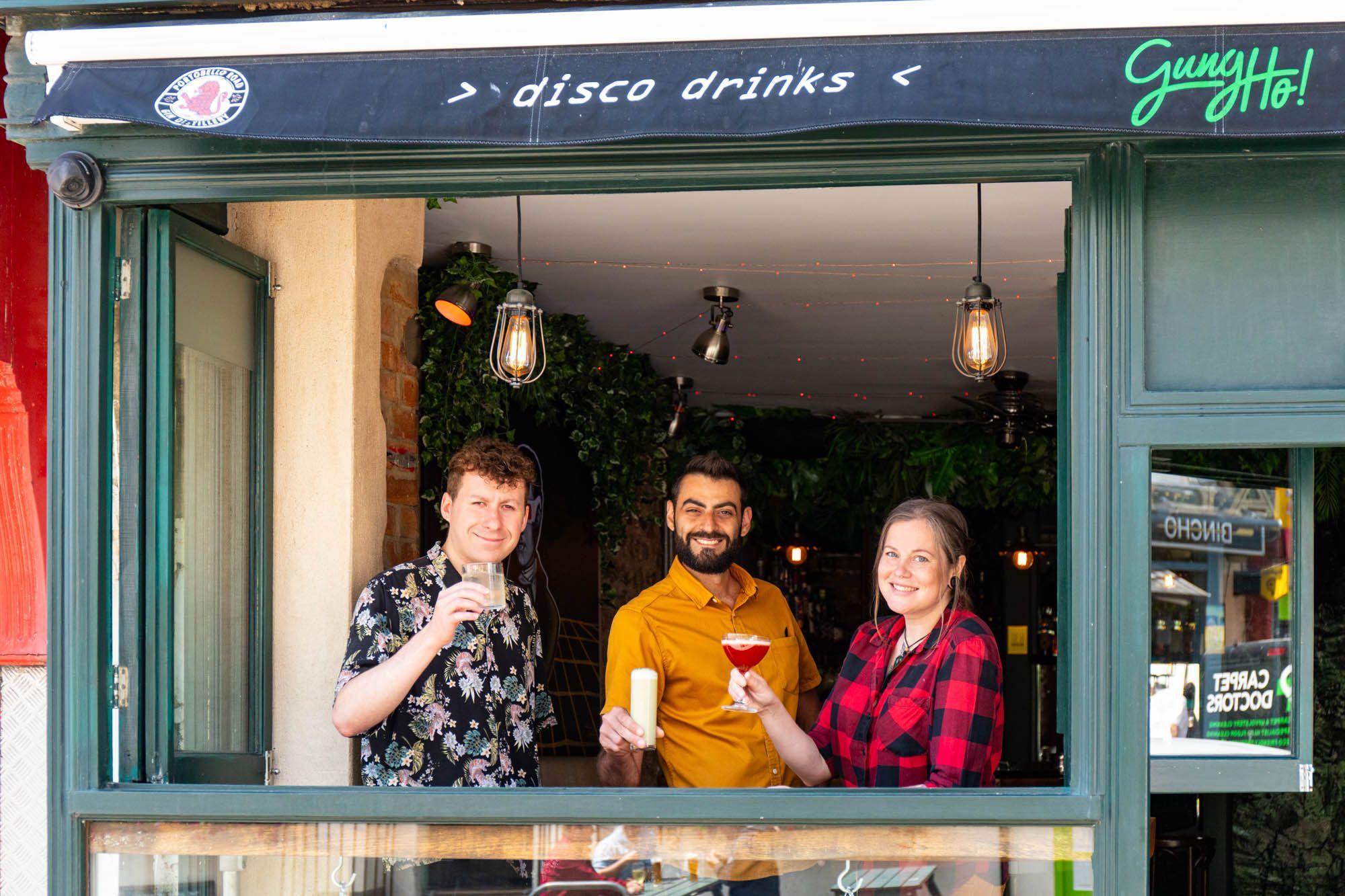 owner Julien and his team standing on the window of Gung Ho bar in Brighton