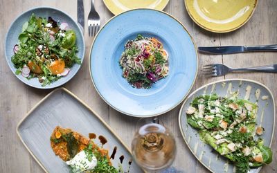 Fresh salads with butternut squash and dressings served in blue and grey ceramic plates