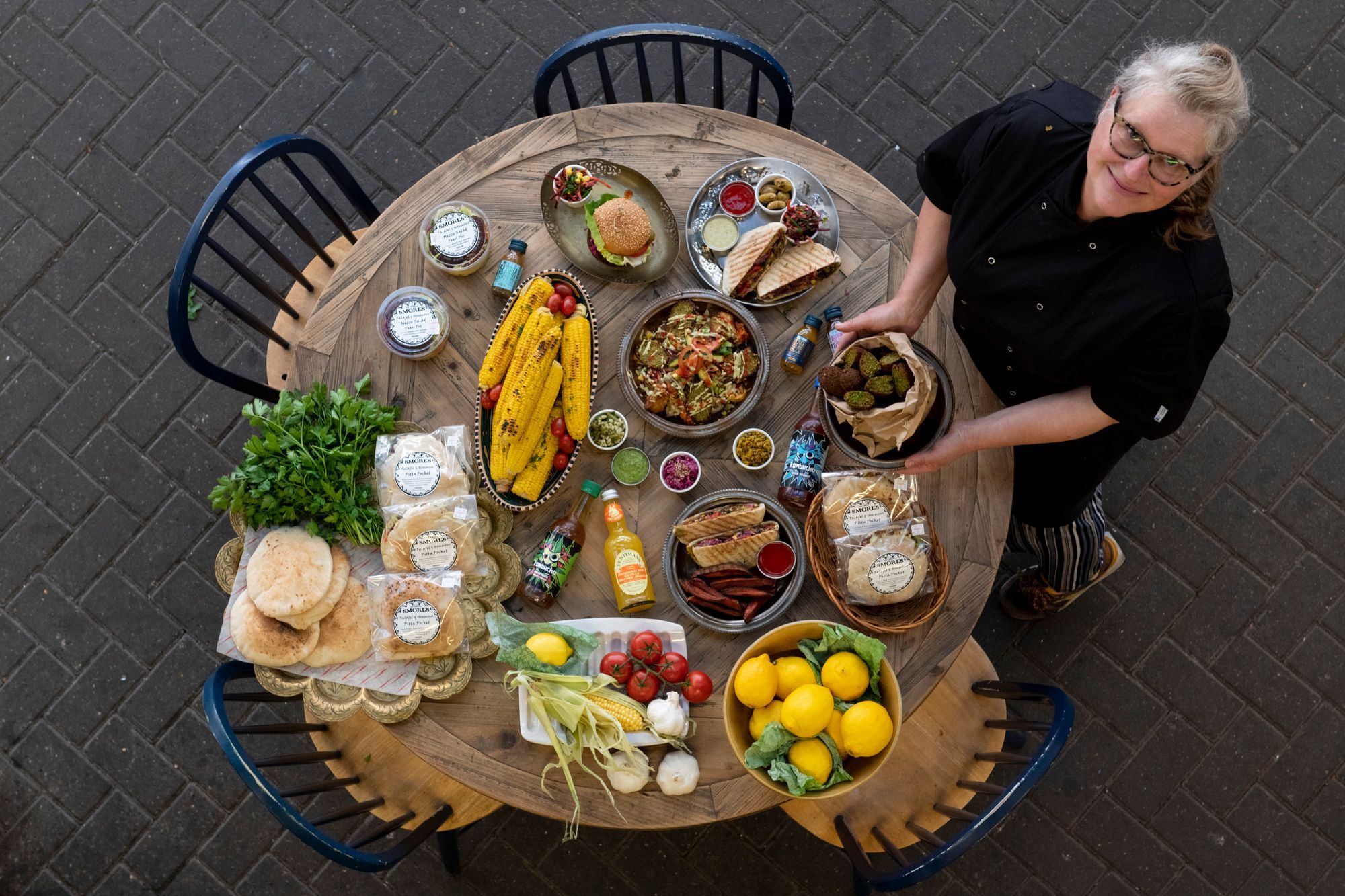 Sarah. the owner of Smorls standing next to the table full of food