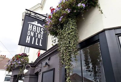 Exterior of Haus on the Hill with hanging basket of flowers.