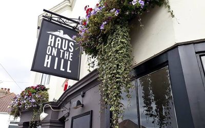 Exterior of Haus on the Hill with hanging basket of flowers.