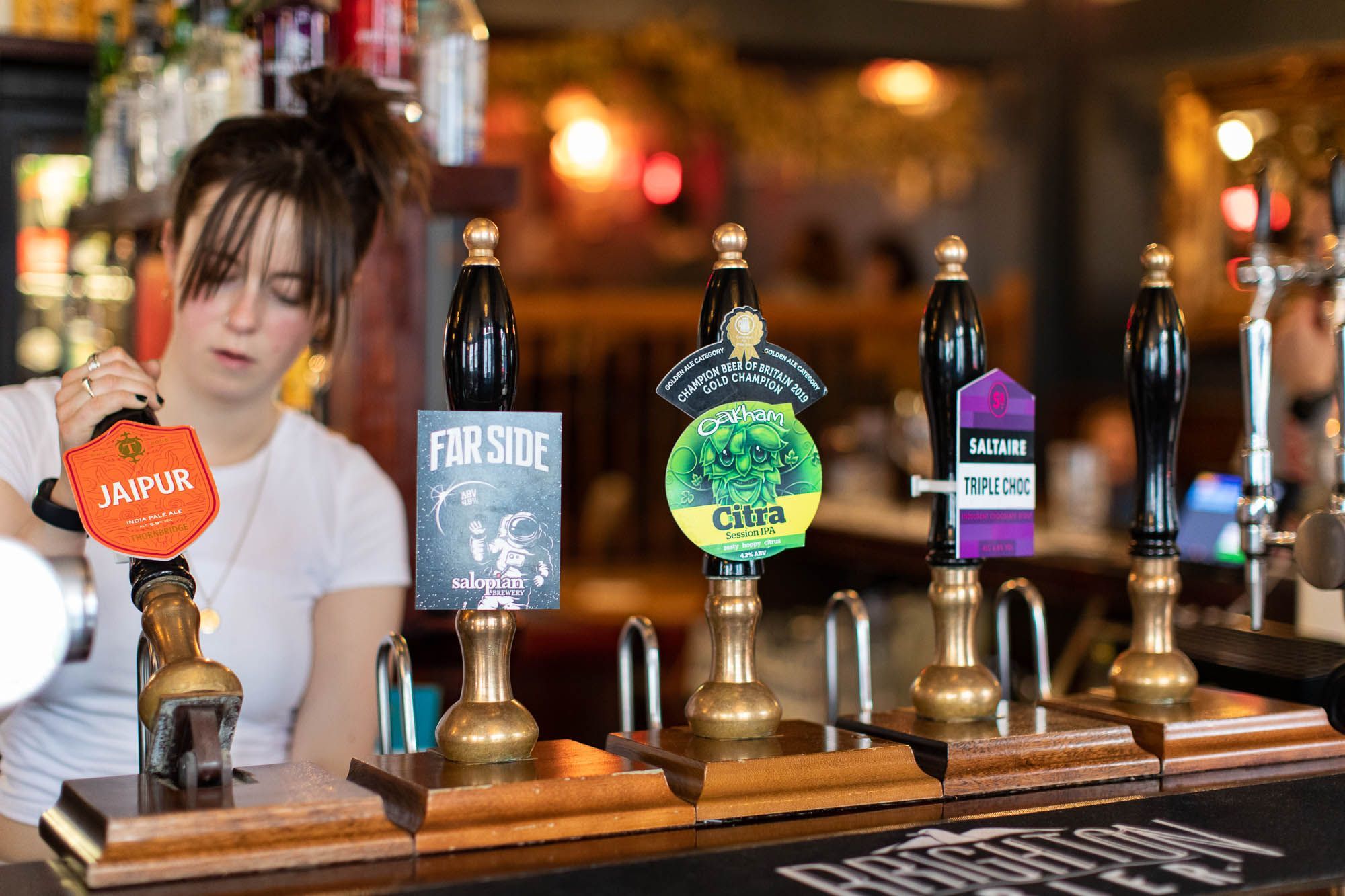 bartender filling glass while using beer tap