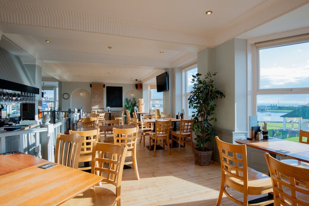 The Gather Inn Brighton. Sunday roast Brighton. Brighton Restaurant Awards. The picture shows many wooden chairs and tables in the light and spacious bar room. This is a Brighton seafront restaurant with views over Hove Lagoon area at the far end of Brighton.