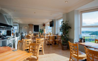 The Gather Inn Brighton. Sunday roast Brighton. Brighton Restaurant Awards. The picture shows many wooden chairs and tables in the light and spacious bar room. This is a Brighton seafront restaurant with views over Hove Lagoon area at the far end of Brighton.