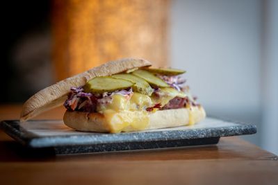 Panini sandwich with melted cheese, red cabbage and pickles. Served on a marble tray.
