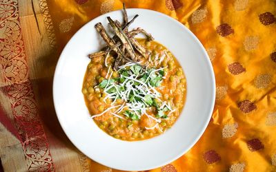 Delicious looking white bowl of orange chickpea daal. Vegetarian restaurant Brighton