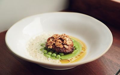 A large deep dish with a creamy pea puree topped with a piece of red meat and toasted flaked almonds. Wild Flor, Hove restaurant