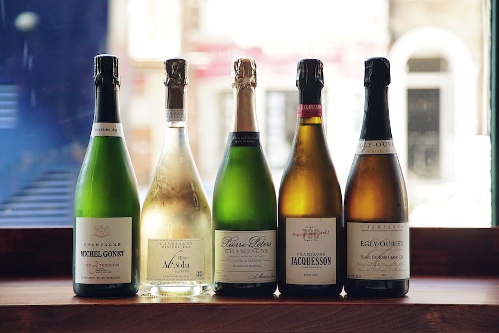 Bottles of wine lined up in front of a window