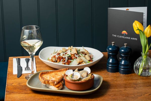 two dishes including, chicken salad and toast and shells, served with glass of white wine at The Cleveland Arms