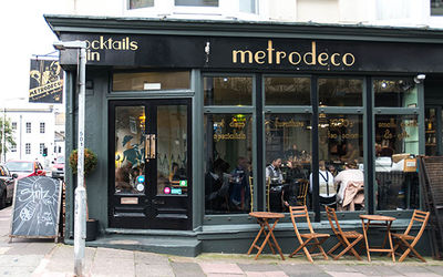 Street photograph of the Metrodeco building with outside seating and floor to ceiling windows. Brighton brunch