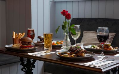 Roast dinners and burgers served at the table with glasses of wine and beer
