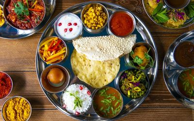 Indian Thali tray with dips, poppadoms and curries