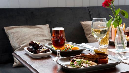 Cushioned indoor seating serving plates of food with a glass of ale