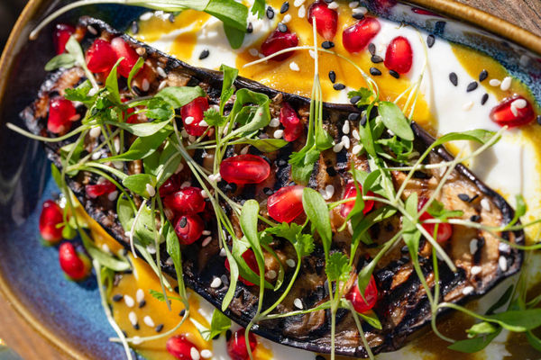 Close up of the colourful ingredients of an aubergine dish.