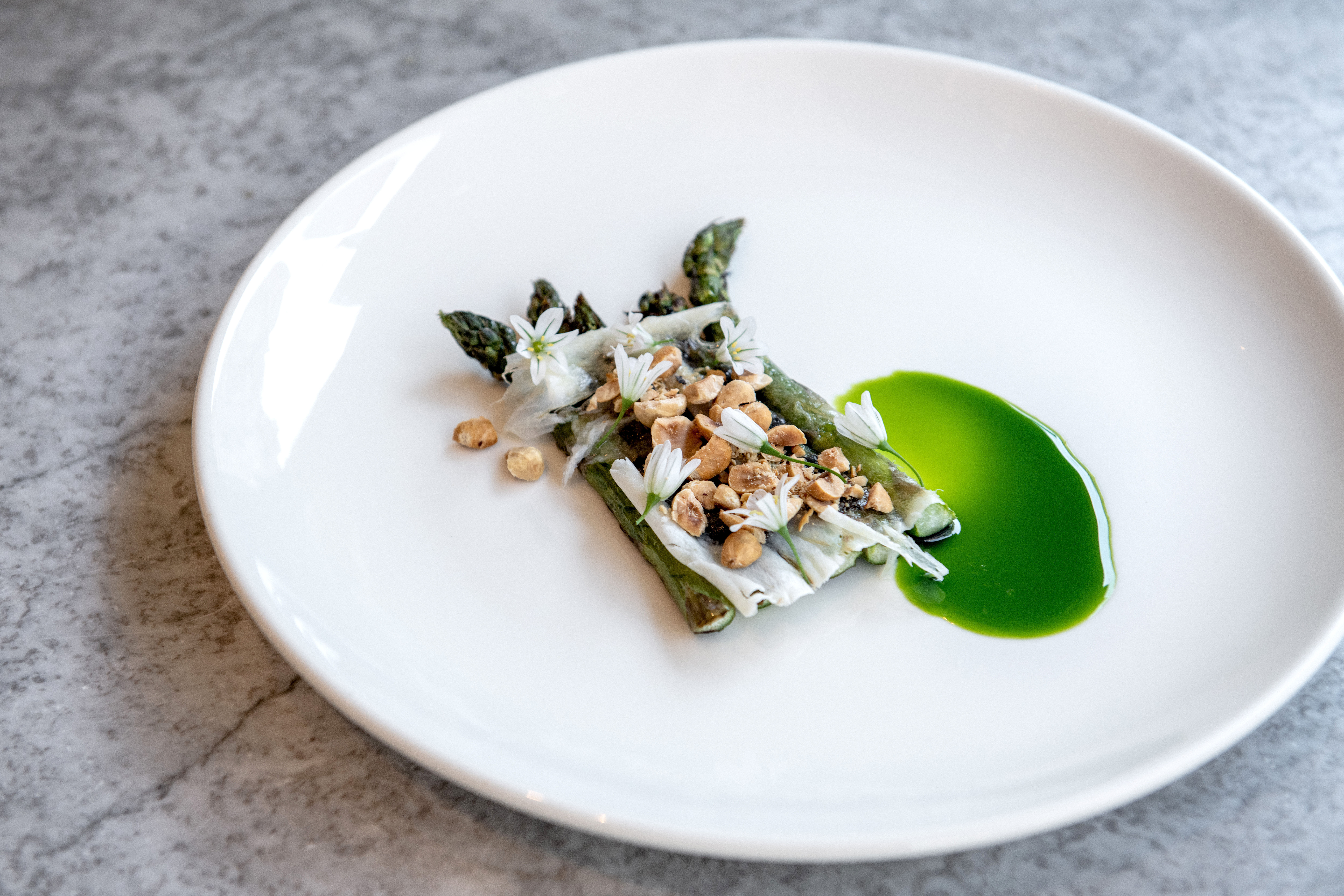 over head shot of the asparagus dish served on the white round plate