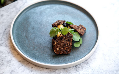 side shot of the dish served in round grey plate at the Kindling Brighton